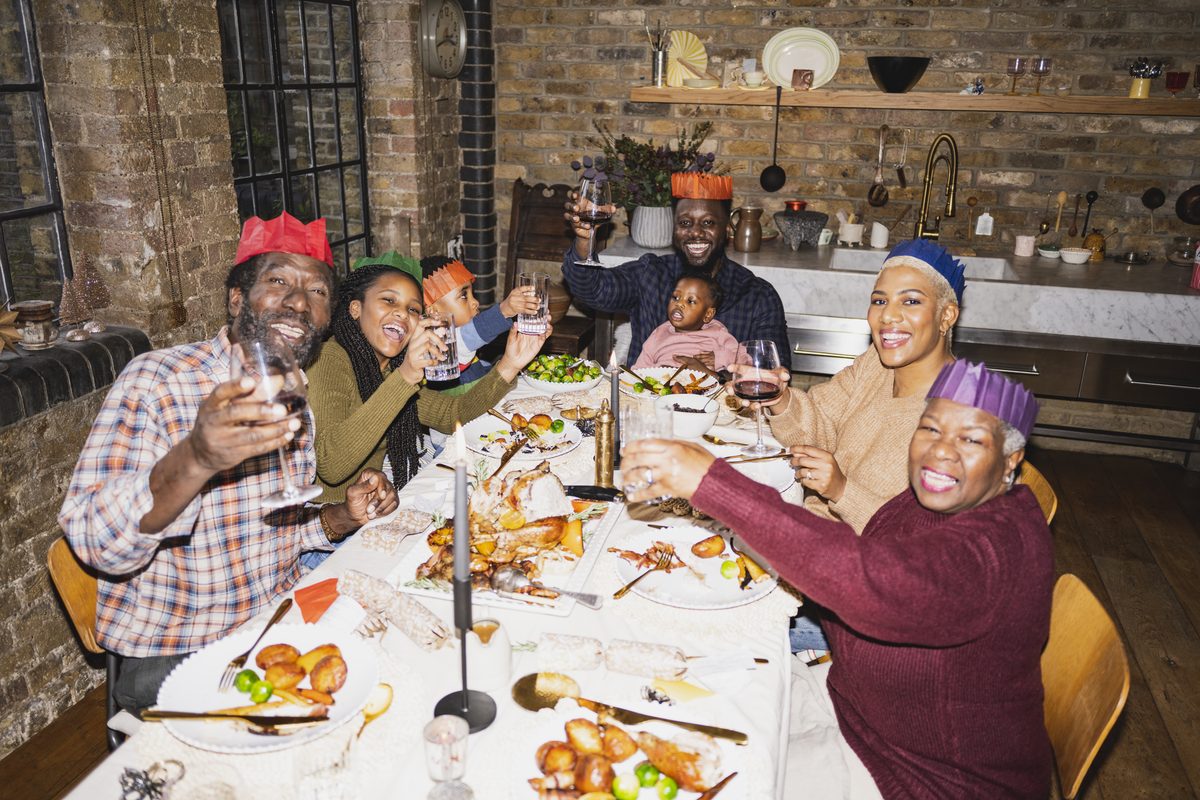 A multi-generational family raising a toast at a festive holiday dinner
